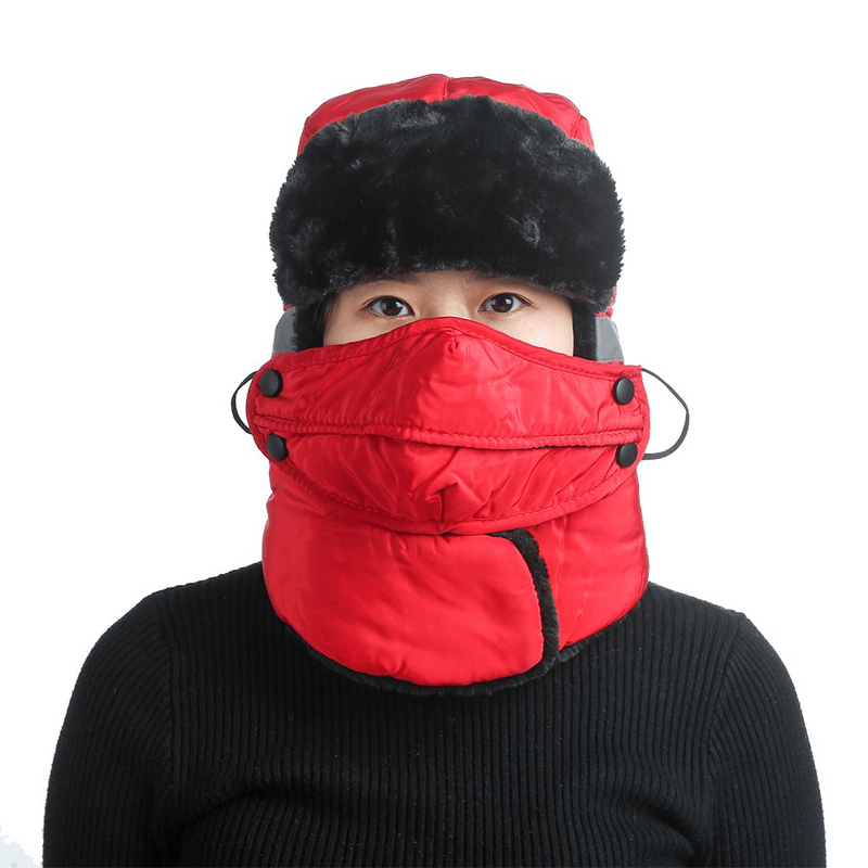 Person wearing red winter windproof ski cap with earflaps and closed neck for outdoor protection.
